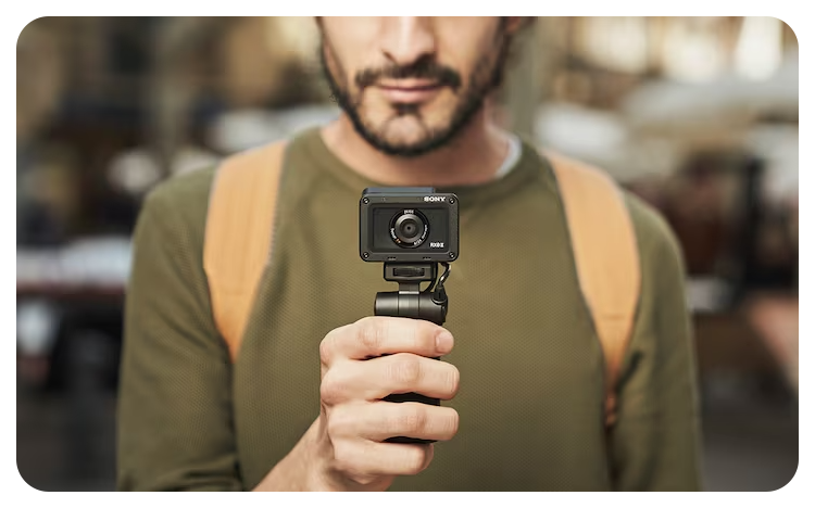 person holding Sony RX0 II Camera on mini tripod shooting grip
